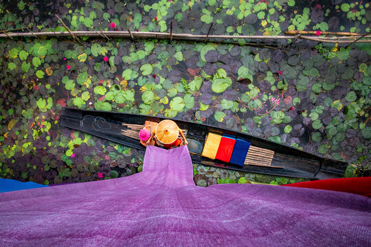 View of colorful cloth drying and a mother and child in a boat on Inle Lake, Shan State, Myanmar.
