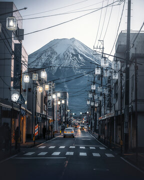 Fujiyoshida, Japan - 03 December 2022: View of majestic Mt. Fuji at dusk with serene cityscape of Fujiyoshida, Yamanashi, Japan.