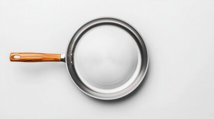 Fototapeta premium Topdown view of a stainless steel frying pan with a wooden handle, minimal design, white backdrop