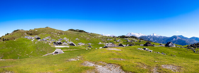 View of serene alpine pasture with picturesque hut village and breathtaking mountain landscape, Velika Planina, Kamnik, Slovenia.