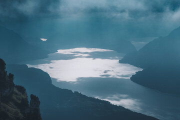 View of serene lake surrounded by majestic mountains under a cloudy sky, Stoos, Schwyz, Switzerland.