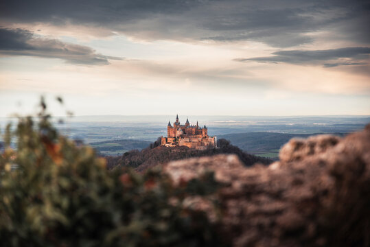 View of majestic Hohenzollern Castle on a hilltop under a dramatic sky with clouds, Stuttgart, Germany.