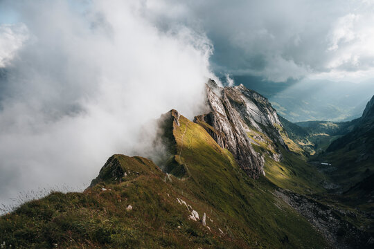 View of majestic mountains with clouds over a picturesque valley, Brulisau, Appenzell, Switzerland.