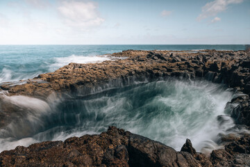 View of dramatic rocky coastline with powerful waves crashing, Salinas El Bufadero, Gran Canaria, Spain.