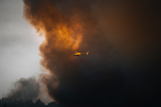 View of a dramatic forest fire with thick smoke and a helicopter in action, Cueva del Viento, Santa Cruz de Tenerife, Spain.