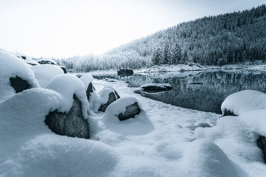 View of serene snowy landscape with frozen lake and majestic mountains, Flims, Graubunden, Switzerland.