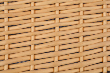 A close-up shot of woven rattan with a visible underlying fabric, creating a textured pattern