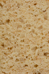 A close-up shot of a slice of homemade bread with sunflower seeds, showcasing its porous texture and natural color