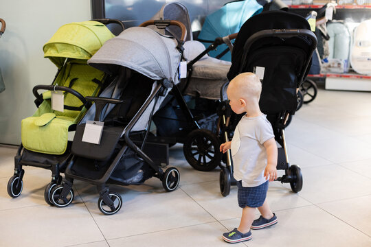Little child choosing a troller in a shop. 