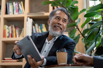 Engagement and Digital Interaction. A senior man enthusiastically sharing his ideas with a tablet...