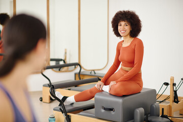 Embracing strength and flexibility in a lively pilates studio with eager participants