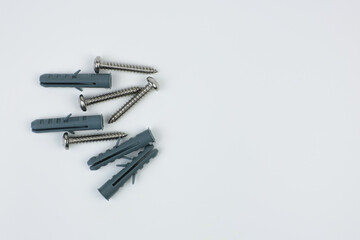 close-up iron screws with gray dowels on a white background on the left with space for text. Concept of repair, construction. High quality photo