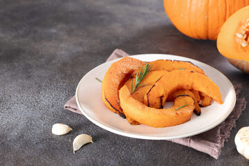 Roasted pumpkin slices with garlic and rosemary. Vegetarian food.