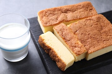 Tasty Japanese Castella sponge cake and milk on grey table, closeup