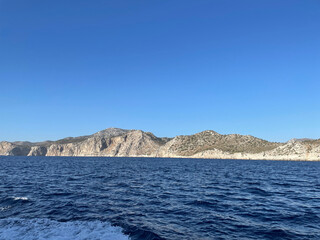 Serene view of a rocky coastline and clear blue waters under a bright sky