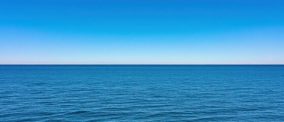 Obraz premium Tranquil Ocean Scene: Azure Waters Under a Clear Blue Sky