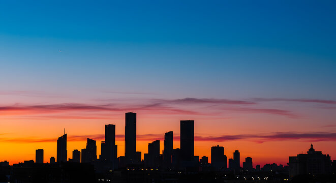 A peaceful sunset in the city, with skyscrapers silhouetted against a colorful sky.