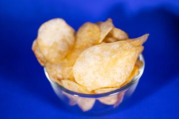 Potato chips on blue color background, Most unhealthy junk food