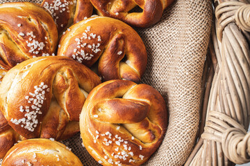 Pretzels with coarse salt. on canvas in a wicker basket with ears of wheat.