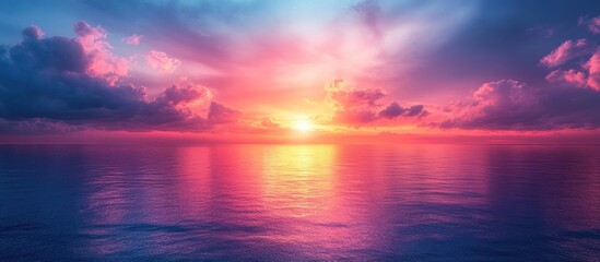 Fototapeta premium Vibrant sunset over calm ocean; colorful sky with clouds reflecting on water.