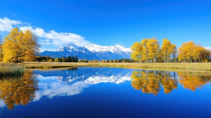 Fototapeta premium Mountains and autumn trees reflect on a serene lake surface