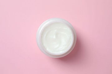 Jar with moisturizer cream. Natural cosmetic products on color background, top view
