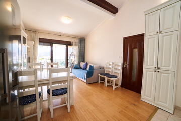 Spacious dining room with a large fold-out sofa, table, chairs, double-door refrigerator and wardrobe