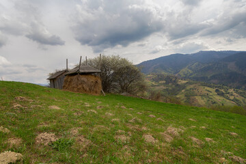 Obraz premium Cozy landscape with a haystack in spring in the Carpathians