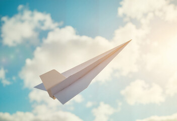 White paper airplane soaring in the air against a blue sky