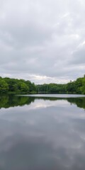  Still Lake in a Lush Green Forest with Peaceful Reflections on a Cloudy Summer Day