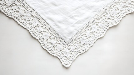 A white cloth with detailed lace edges folded on a surface