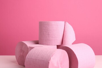 Color toilet paper rolls on pink background