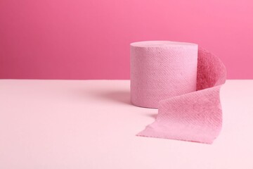 Color toilet paper roll on pink background. Space for text