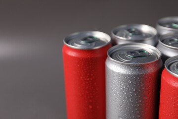 Many aluminium cans of beverage on grey background, closeup. Space for text