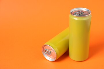 Two tin cans on orange background. Space for text