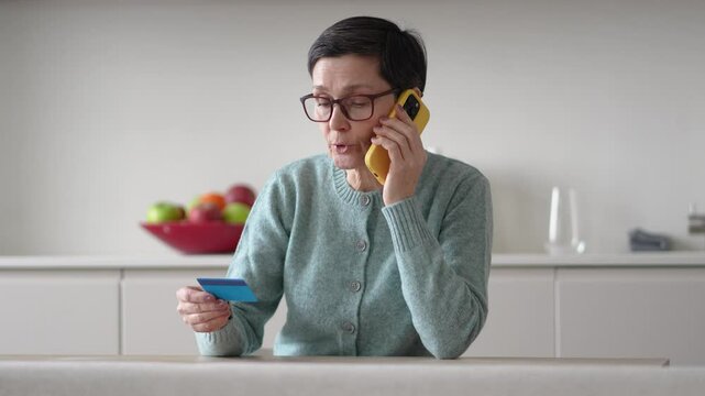 Anxious scared vulnerable woman sending money from accounts to fraudsters on phone. Financial scam, credit card manipulation, identity theft, phone fraud, deception, confusion and exploitation