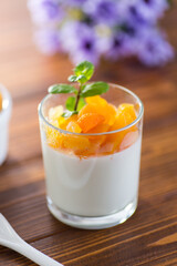 Light fruit yogurt with dried apricots on dark wooden table