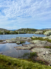 Fototapeta premium Mountain lake in Norway, Kjerag region, rocky shore and grass