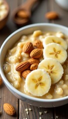 Close-up of a bowl of creamy oatmeal with sliced bananas and almonds on top, banana, porridge, meal