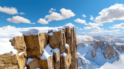 Snow Covered Mountaintop Cliff overlooking Snowy Range under Blue Sky