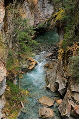 Scenic green, turquoise blue water of Johnston Crek running along the bottom of Johnston Canyon...