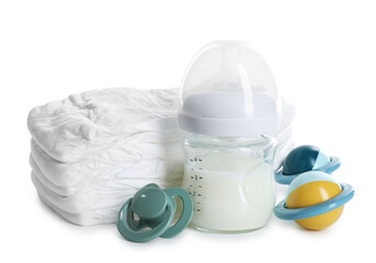 Feeding bottle with milk, diapers, baby rattle and pacifier isolated on white