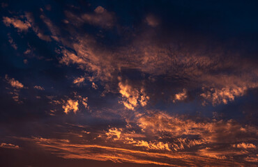 Stunning dramatic sunset sky with golden clouds and deep blue and purple texture
