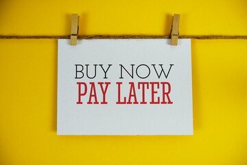 Buy Now Pay Later text on paper card on yellow background