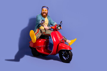 Stylish bearded man on a scooter against a purple background captures a vibrant retro fashion vibe...