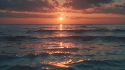 Obraz premium The evening sun reflects off the calm surface of the sea. The ocean's warm tones are truly authentic. Sunset above a bubbly sea of small waves. Dawn lit up the ocean. Beautiful scenery.