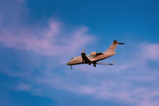 Private jet Bombardier Challenger 300 descending at sunset with