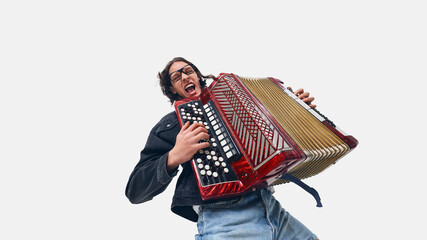 Excited young man, accordion player in black jacket rocking out, playing with energy and passion on...