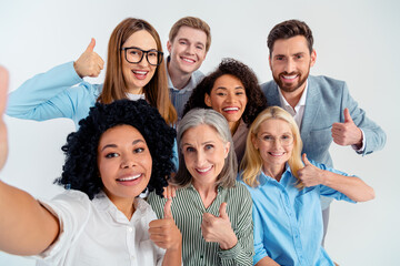 Group of diverse business colleagues giving a thumbs up in a corporate office setting