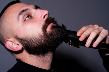 Shaving beard. Barber making beard for bearded man at barbershop. Hairstyle, salon, hairdresser,...